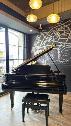 a black piano in a room with a wall at TK Happiness 168 B&B in Donggang