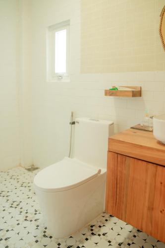 a bathroom with a white toilet and a sink at Hoang Yen Villa & Coffee in Da Lat