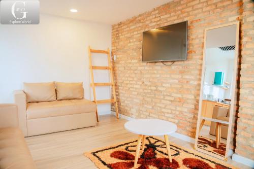 a living room with a couch and a brick wall at Hoang Yen Villa & Coffee in Da Lat