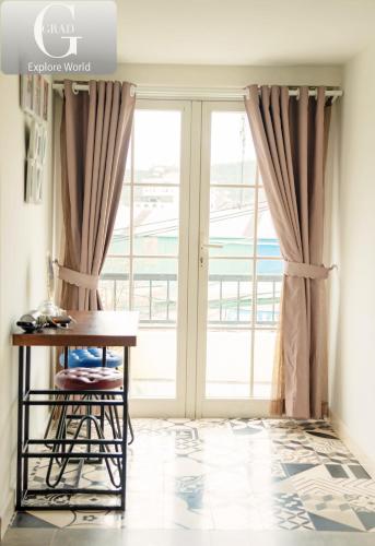 a room with a desk and a large window at Hoang Yen Villa & Coffee in Da Lat