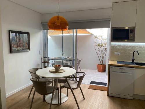 a kitchen and dining room with a table and chairs at Casa do Lado - Vila Franca do Campo - AL in Vila Franca do Campo