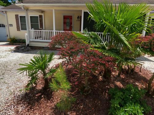 a house with palm trees and flowers in front of it at Ranch with Cactuses in Millsboro
