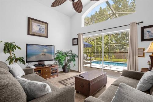 a living room with a tv and a large window at 201-4-HB-Beautiful home at TerraVerde in Kissimmee