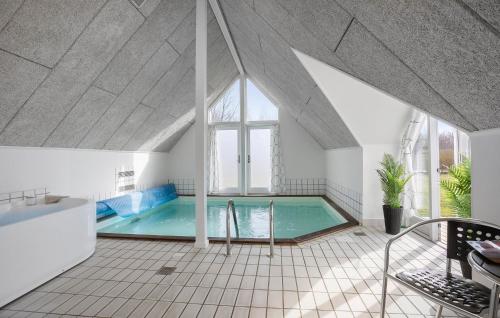 a swimming pool in a room with an attic at Awesome Home In Rudkøbing With Sauna in Spodsbjerg