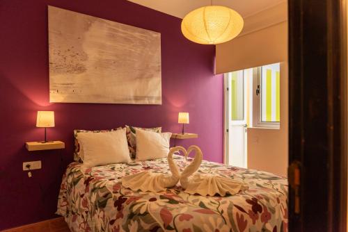 Un dormitorio con paredes moradas y una cama con un cisne. en Lanzarote Beach, en Arrecife