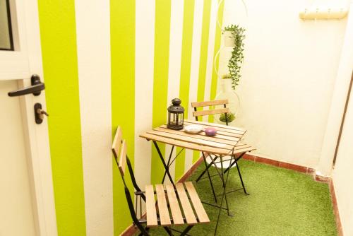 mesa pequeña y sillas en una habitación con rayas verdes y blancas en Lanzarote Beach, en Arrecife