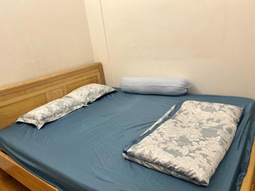 a bed with a blue sheet and a pillow on it at Osimi Phu My Apartment - 1 and 2 bedrooms in Phú Mỹ