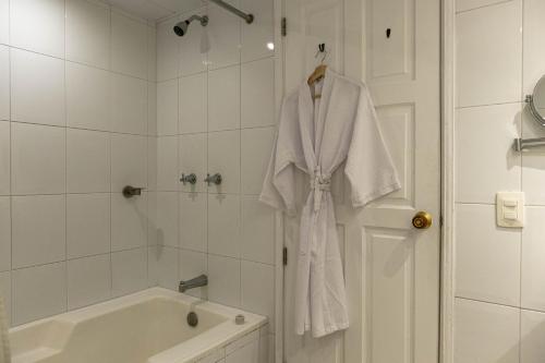a bathroom with a robe hanging on a shower door at Hotel Caribe by Faranda Grand, a member of Radisson Individuals in Cartagena de Indias