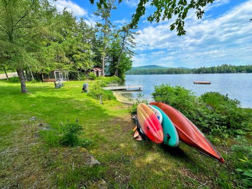dos kayaks sentados en el césped junto a un lago en 91WR Lake vibes and views at this waterfront home in the White Mountains, en Bethlehem