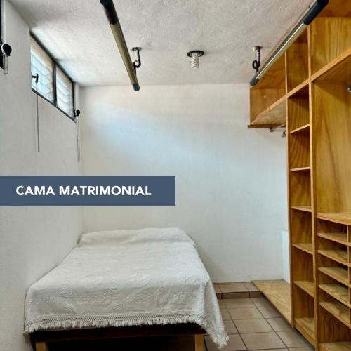 a room with a bed and a book shelf at Talavera II in Querétaro