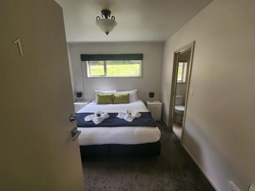 a bedroom with a bed with two towels on it at Pinewood Queenstown in Queenstown