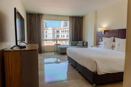 a hotel room with a large bed and a large window at Hotel Caribe by Faranda Grand, a member of Radisson Individuals in Cartagena de Indias