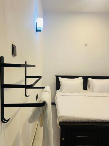 a bedroom with two beds and a light on the wall at Wild Blossom Sigiriya in Sigiriya