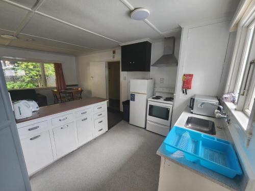 a small kitchen with white cabinets and a sink at Pinewood Queenstown in Queenstown