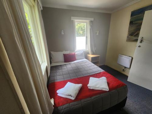 a bedroom with a bed and a window at Pinewood Queenstown in Queenstown