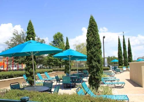 une terrasse avec des chaises et des parasols bleus dans l'établissement 2222-3-SV-Charming condo, à Kissimmee