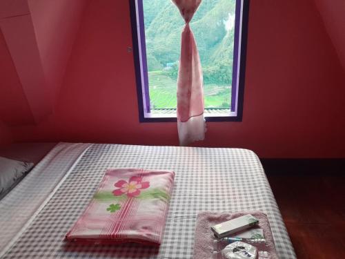 a bedroom with a bed with a tie and a window at Batad Hillside Inn and Restaurant in Banaue