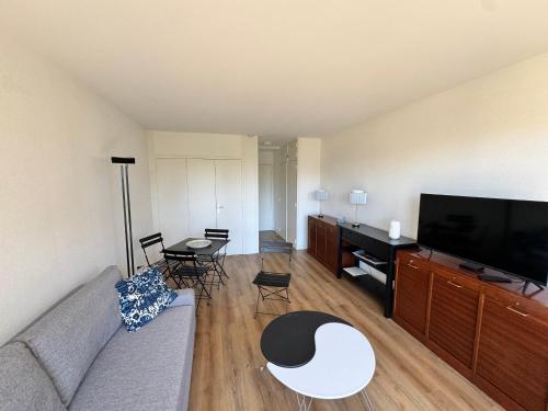 un salon avec un canapé et une télévision à écran plat dans l'établissement Studio rénové avec grand balcon, centre-ville, proche plage - FR-1-712-83, à Villers-sur-Mer