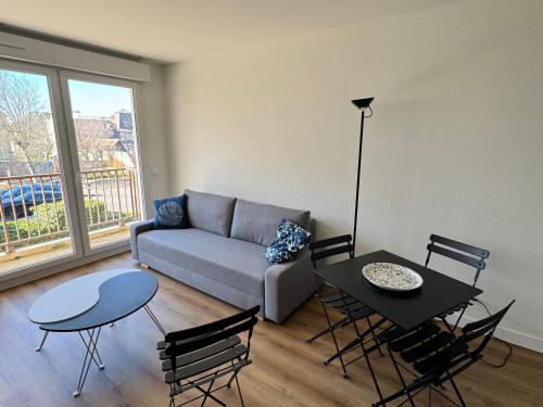 un salon avec un canapé, une table et des chaises dans l'établissement Studio rénové avec grand balcon, centre-ville, proche plage - FR-1-712-83, à Villers-sur-Mer