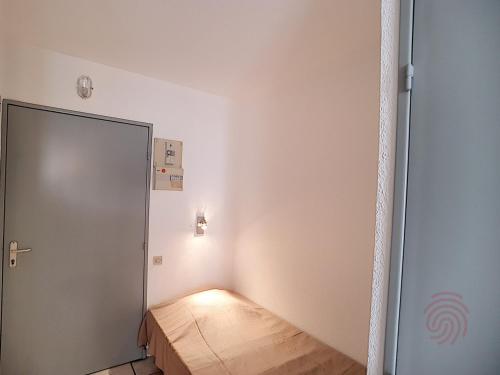 Cette petite chambre dispose d'une porte et d'un lit. dans l'établissement Studio rénové avec balcon, proche des Thermes de Lamalou, animaux acceptés, parking gratuit. - FR-1-451-131, à Lamalou-les-Bains