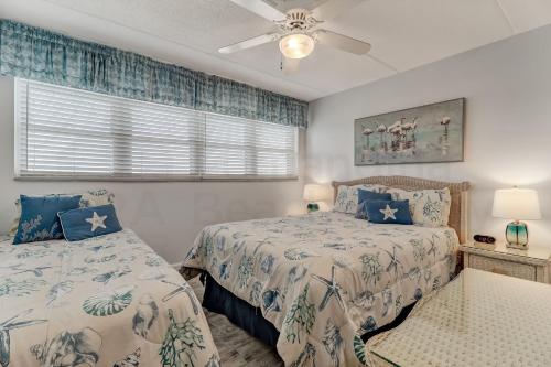 a bedroom with two beds and a ceiling fan at Oceanfront w Beach Access in Amelia Island