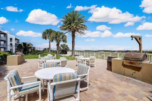 a patio with tables and chairs and a grill at Oceanfront w Beach Access in Amelia Island