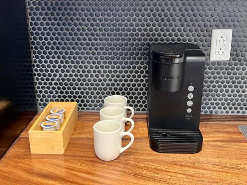 a coffee maker and cups on a wooden table at The Irish Inn Boutique Hotel in Shamrock