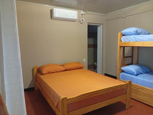 a bedroom with a bed and two bunk beds at Cabañas Misioneras in San Ignacio