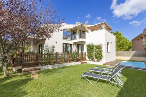 une maison blanche avec une cour dotée de chaises longues dans l'établissement Villa Alcudia - Ferienhaus auf Mallorca mit Pool für bis zu 7 Personen, à Alcúdia