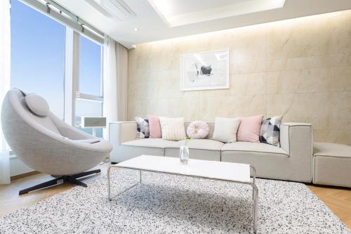 a living room with a couch and a chair at Brown Suites Busan Station in Busan