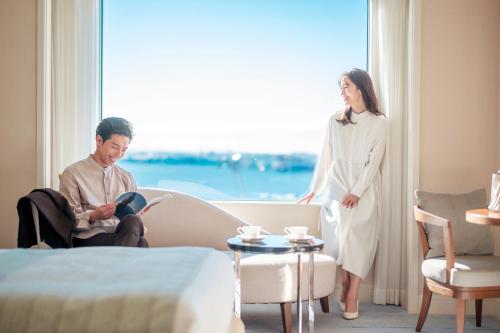 a woman standing next to a man in a hotel room at Grand Nikko Tokyo Daiba in Tokyo