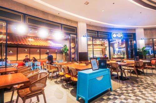 a restaurant with tables and chairs and people sitting at tables at Air Residence Penthouse 59 Suite Gym Swim Park 300 mbps in Manila