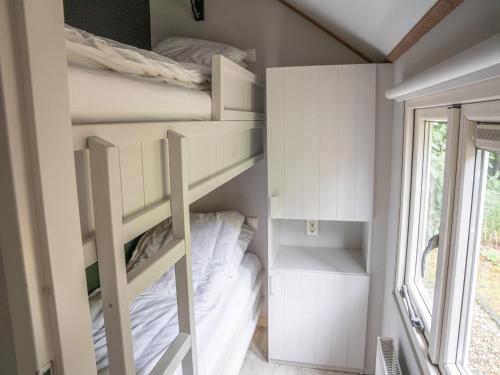 a small bedroom with bunk beds and a window at Pets Welcome, Veluwe Farmhouses for All in Ermelo