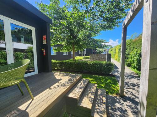 a deck with a chair and a tree at Pinewood Queenstown in Queenstown
