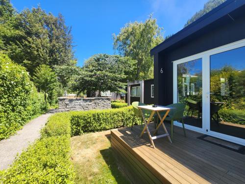 a small deck with a table and chairs on a house at Pinewood Queenstown in Queenstown