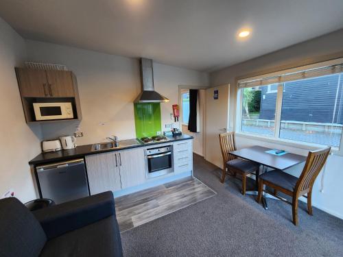 a kitchen with a table and a dining room at Pinewood Queenstown in Queenstown