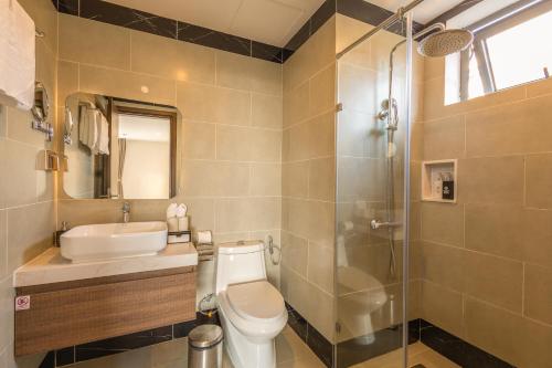 a bathroom with a toilet and a sink and a shower at Sunset Beach Resort and Spa in Phu Quoc