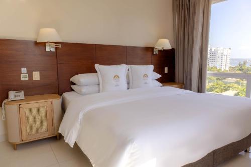 a hotel room with a large bed and a window at Hotel Caribe by Faranda Grand, a member of Radisson Individuals in Cartagena de Indias
