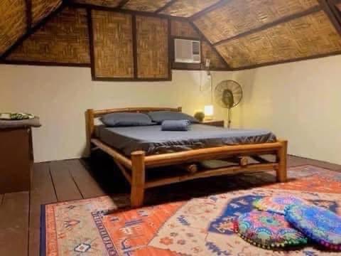 a bedroom with a large bed and a rug at General Luna Guest House in General Luna