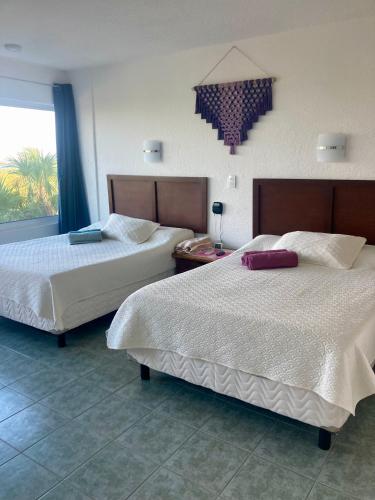 a hotel room with two beds and a window at Lagoon Sunset view entire apartment in Cancún