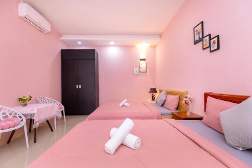 a pink room with two beds and a couch at Căn Hộ "2" OaSky View biển 3 Phòng 5 Giường- Oasky Sea View Apartment in Vung Tau
