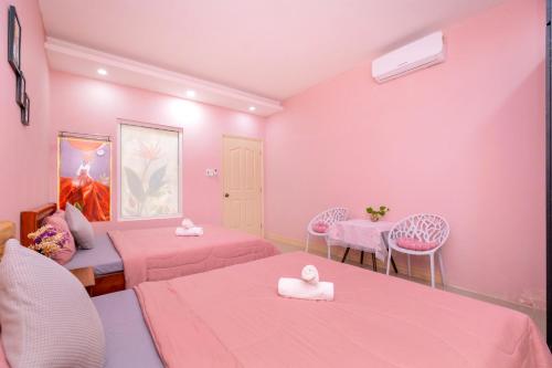 a room with two beds and pink walls at Căn Hộ "2" OaSky View biển 3 Phòng 5 Giường- Oasky Sea View Apartment in Vung Tau