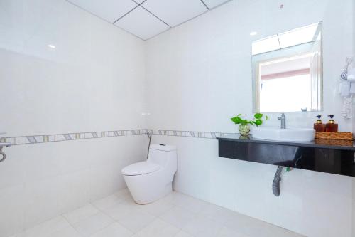 a white bathroom with a toilet and a sink at Căn Hộ "2" OaSky View biển 3 Phòng 5 Giường- Oasky Sea View Apartment in Vung Tau