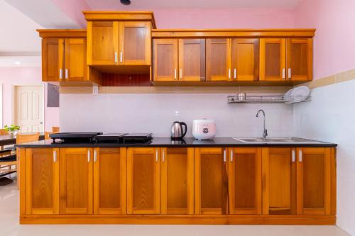 a kitchen with wooden cabinets and a sink at Căn Hộ "2" OaSky View biển 3 Phòng 5 Giường- Oasky Sea View Apartment in Vung Tau