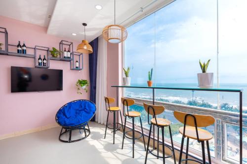 a room with a bar with chairs and a large window at Căn Hộ "2" OaSky View biển 3 Phòng 5 Giường- Oasky Sea View Apartment in Vung Tau