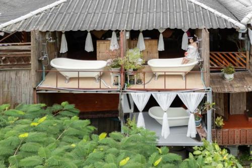a house with two bath tubs on a deck at Monraumsuk home stay Chiang Mai in Ban Pok Nai