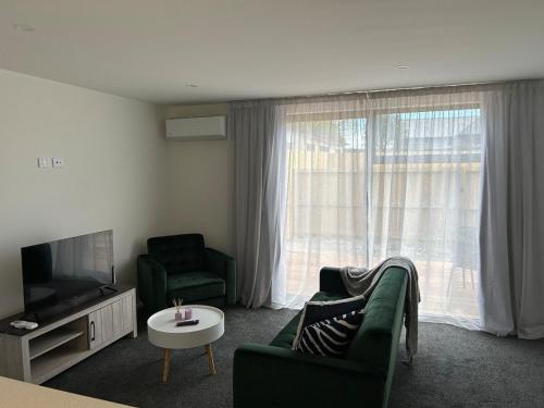 Una sala de estar con un sofá y un televisor. en Apartment 5 on Armagh!, en Christchurch