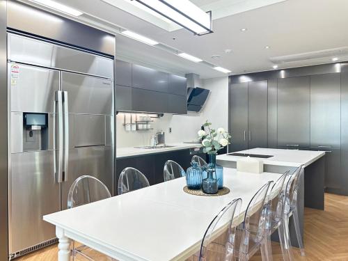a kitchen with a refrigerator and a table with chairs at Brown Suites Busan Station in Busan