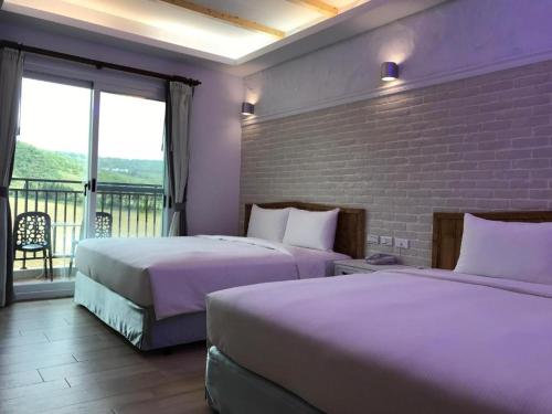 a hotel room with two beds and a balcony at Island on the Sea in Kenting