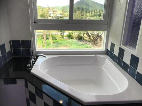 a white bath tub in a bathroom with a window at Island on the Sea in Kenting